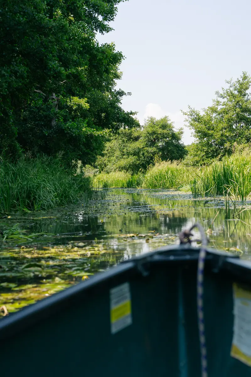 The bow of a canoe heading up the quiet canal