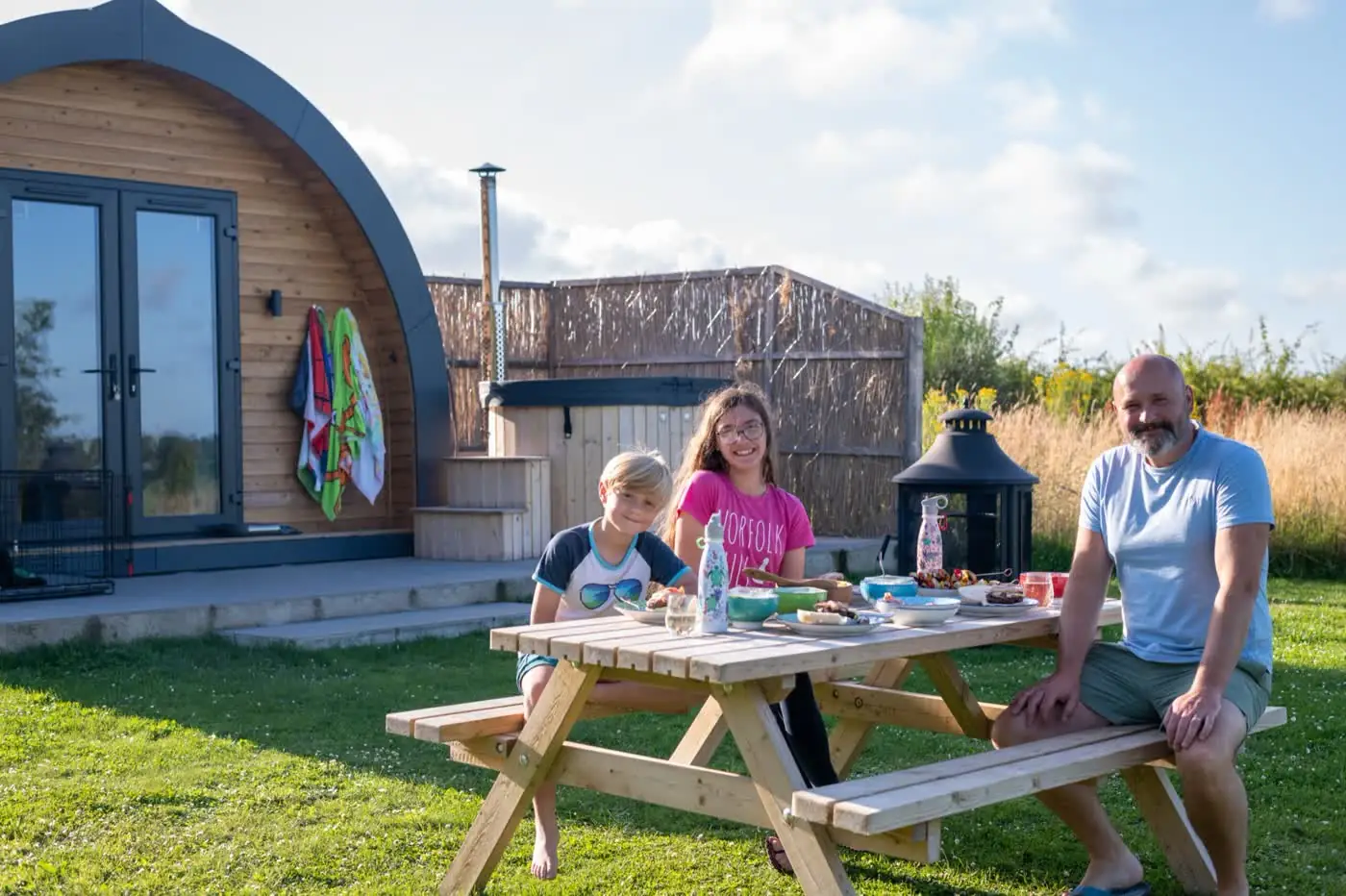 Family at the picnic bench outside the pod